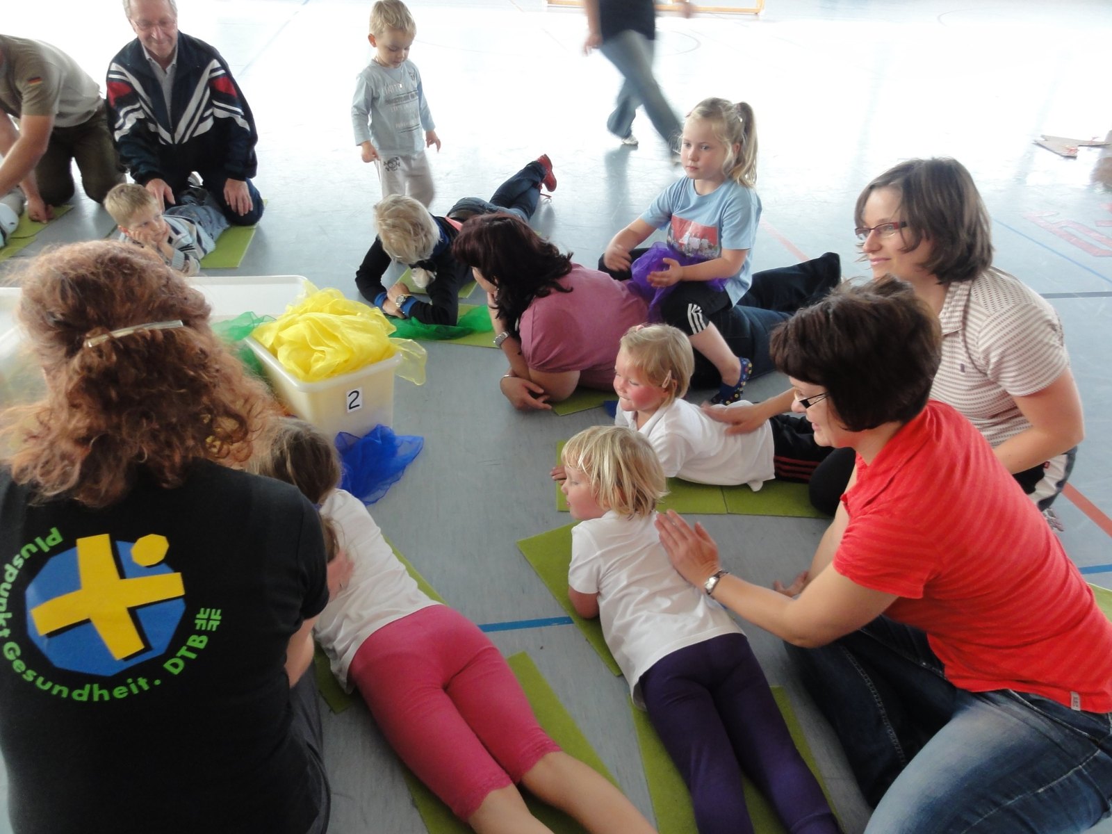 Kinder und Erwachsene bei einer ruhigen Übung auf Matten