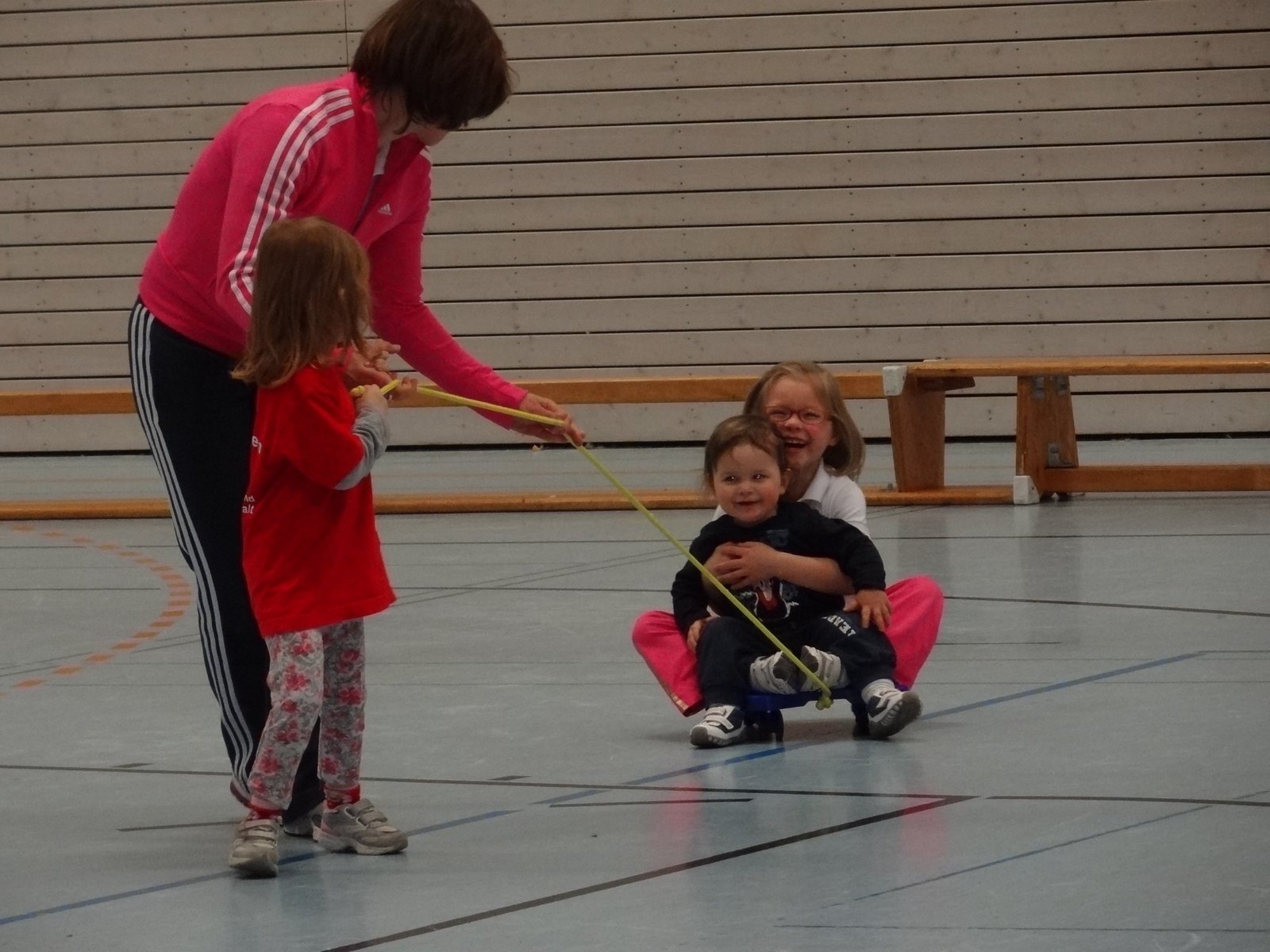 Kinder spielen mit einem Rollbrett in der Sporthalle