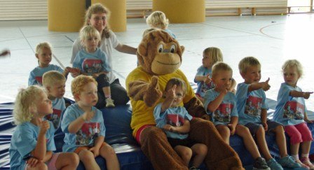 Kindergruppe mit Maskottchen in der Turnhalle